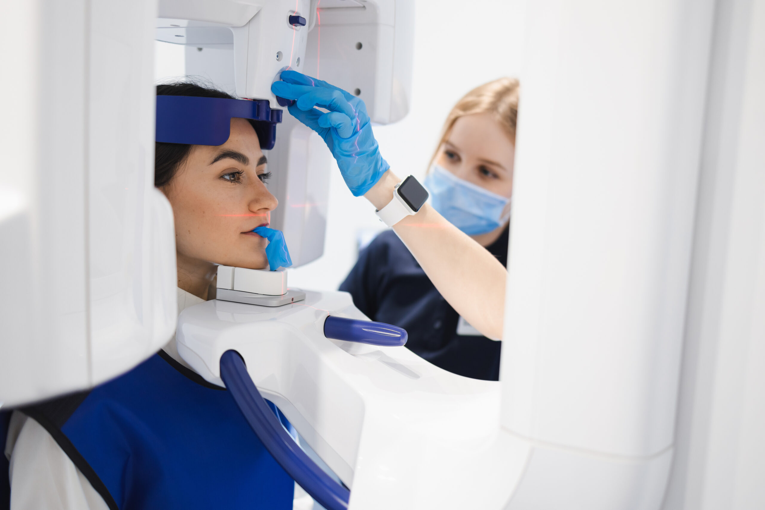 Woman makes a CT scan of the jaw. Dental assistant taking panoramic x-ray for female patient
