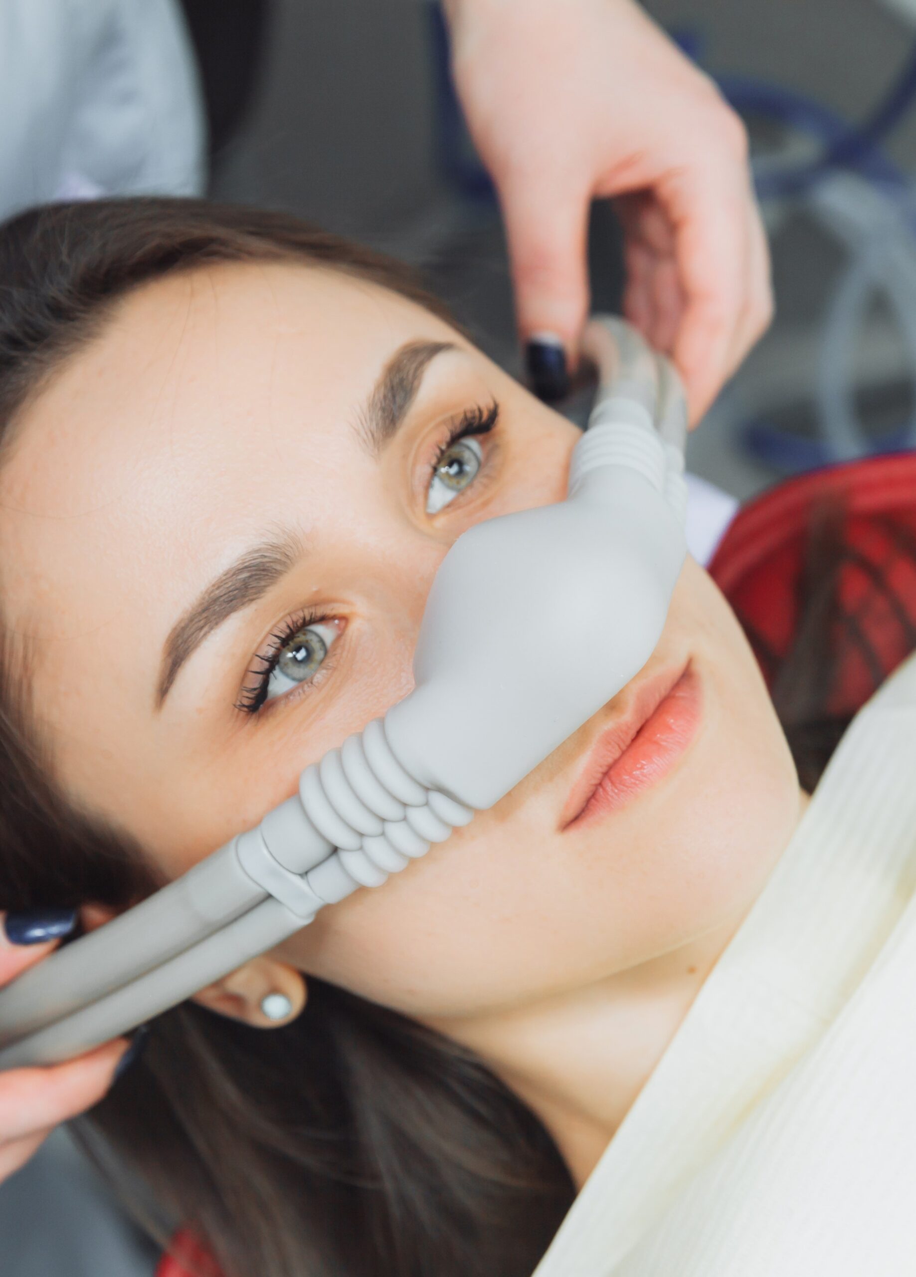 dentist puts inhalation sedative mask on his patient.