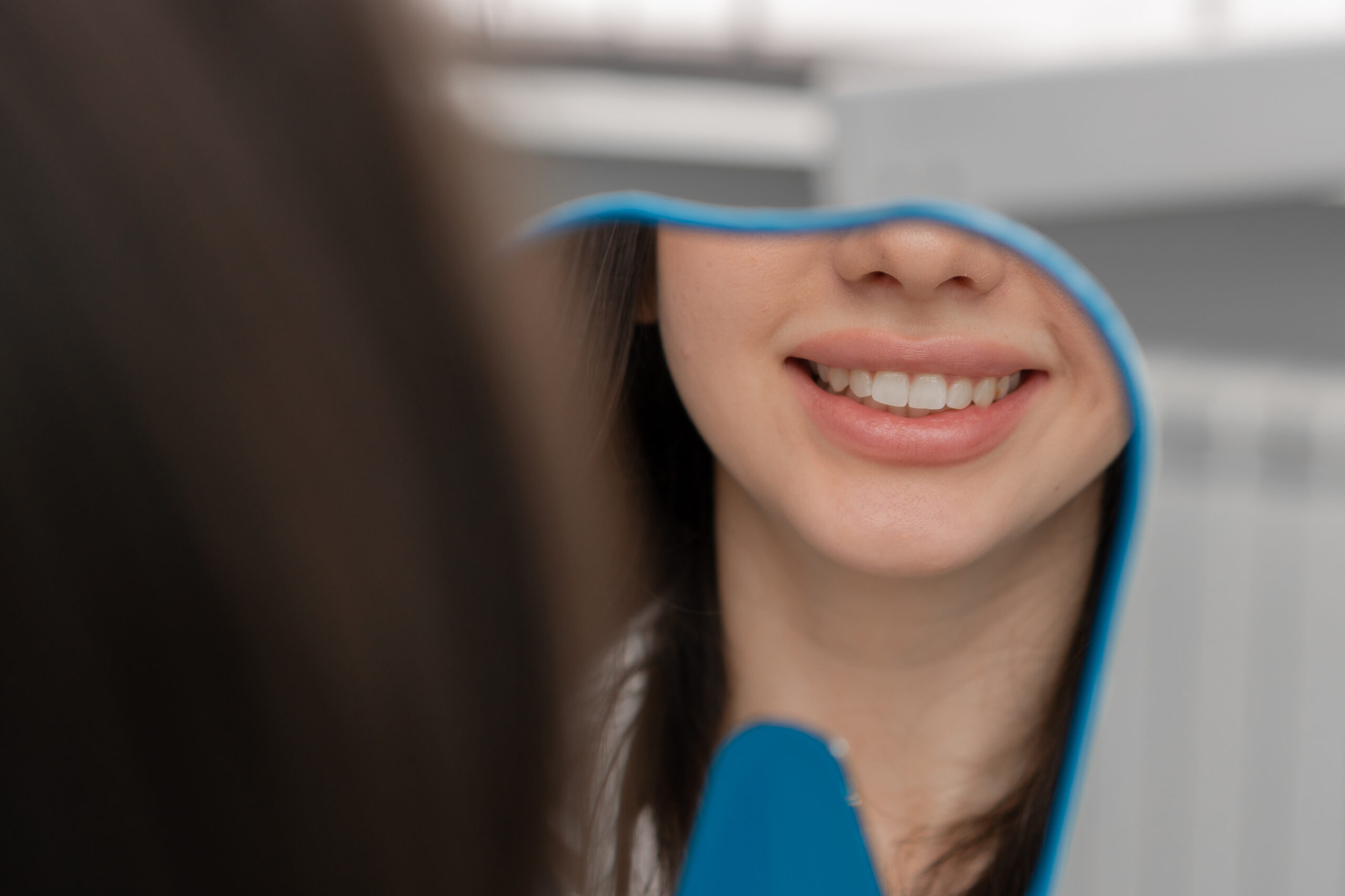 Dentistry a satisfied patient looks in mirror at his teeth